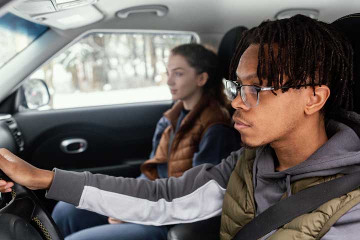Parent teaching teenage driver on road in Jakarta, Indonesia