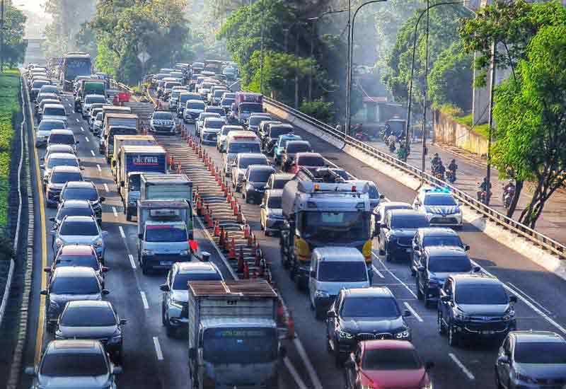 Traffic rules in Indonesia with various vehicles including cars and motorcycles