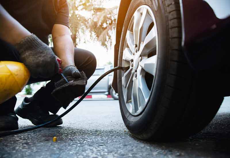 A mechanic inspecting for car tires maintenance.