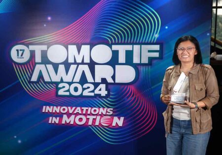 A person holding a trophy stands in front of a backdrop with the text "TOMOTIF AWARD 2024."