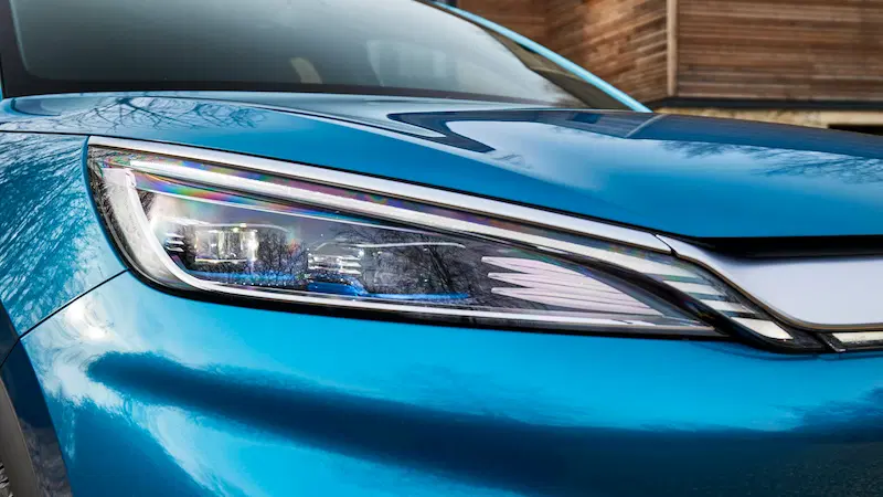 close-up of the front headlight of a blue BYD Atto 3 electric car