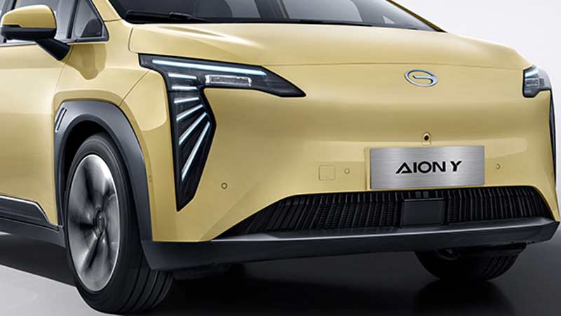 Front view of a gold GAC Aion Y electric vehicle with distinctive LED headlights.