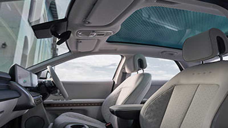 Hyundai Ioniq 5 interior with panoramic sunroof and light-colored seats.