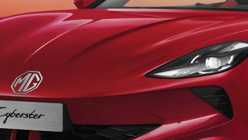Front view of a red MG Cyberster sports car with the MG logo prominently displayed on the hood.