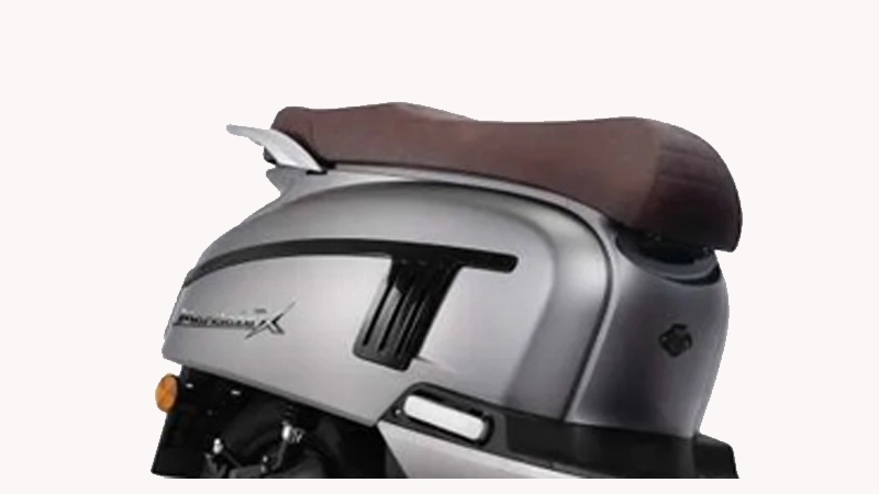 A rear view of a scooter seat, showcasing a brown leather cushion, a silver metal frame, and a chrome grab handle.